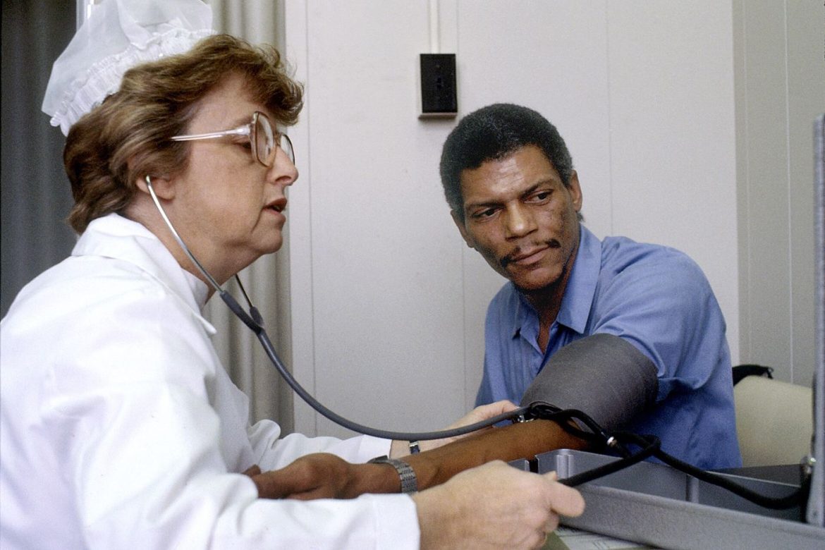 nurse measuring patient blood pressure in clinic